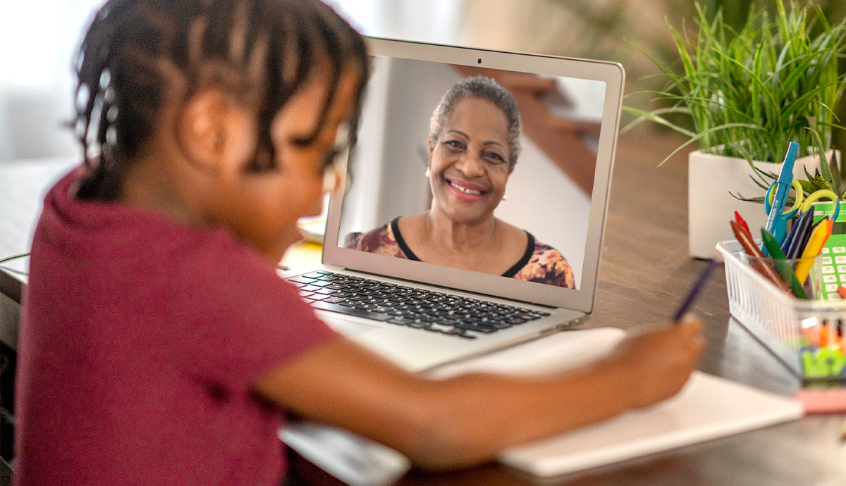 An image looking over a child’s shoulder as they video chat with an Experience Corps virtual tutor.